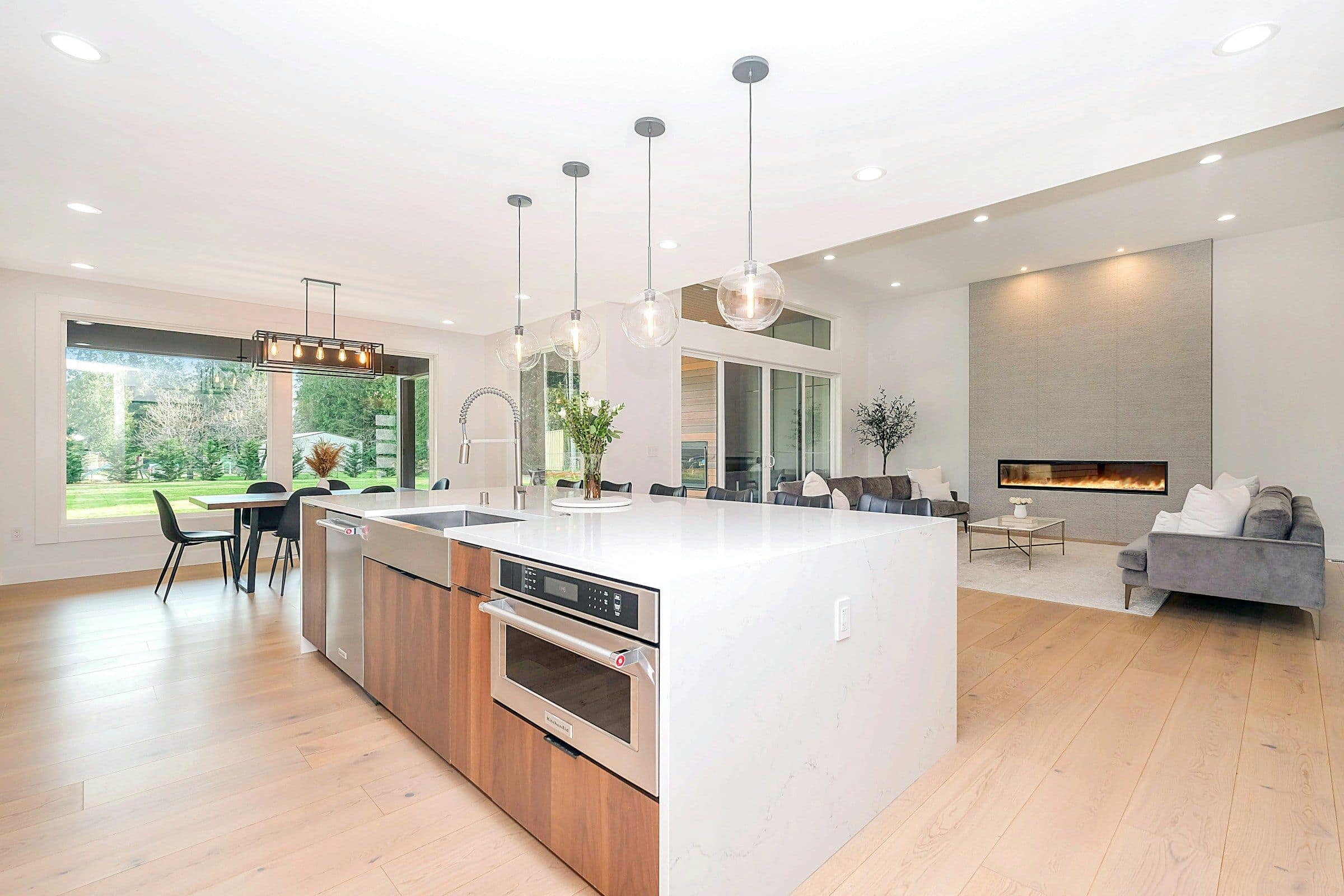 A renovated open-plan kitchen with a white island and timber cabinetry